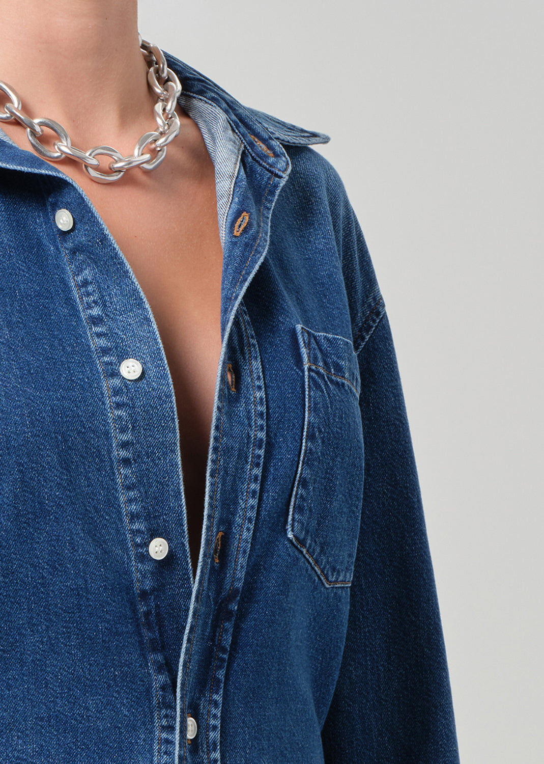close up of a blue denim shirt worn by a person