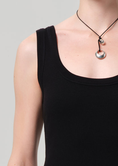 Person wearing a black sleeveless dress on a grey background
