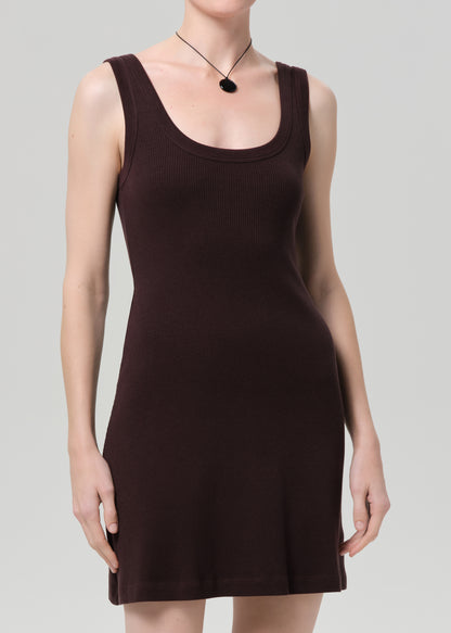 Person wearing a brown sleeveless dress on a plain background