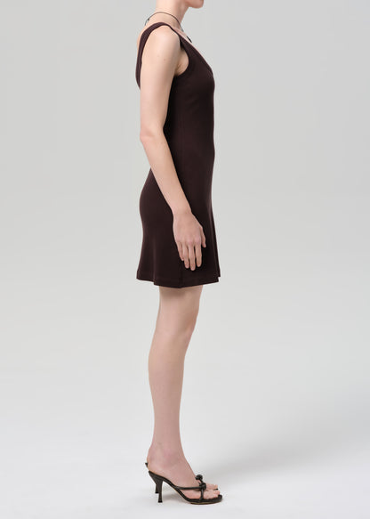 Person wearing a brown sleeveless dress on a plain background