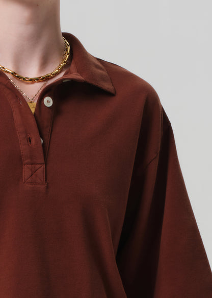 Brown long-sleeve shirt worn by a person on a plain background