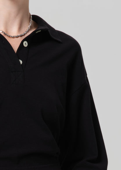 Black shirt with white buttons on a plain background