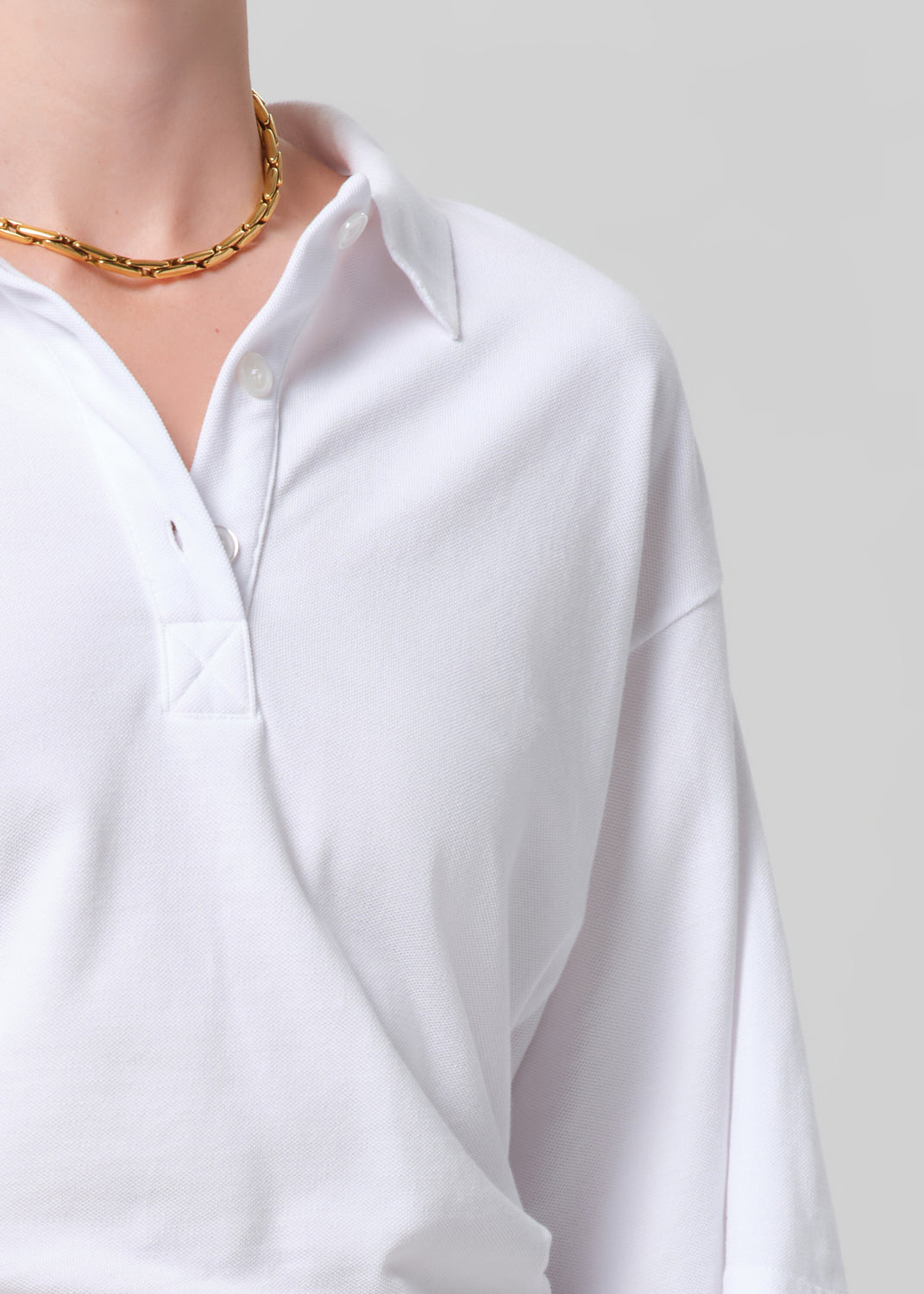 White shirt worn by a person on a plain background