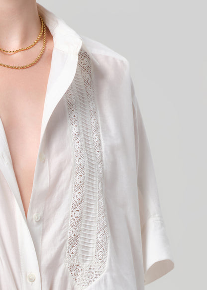 White blouse with lace detailing on a plain background