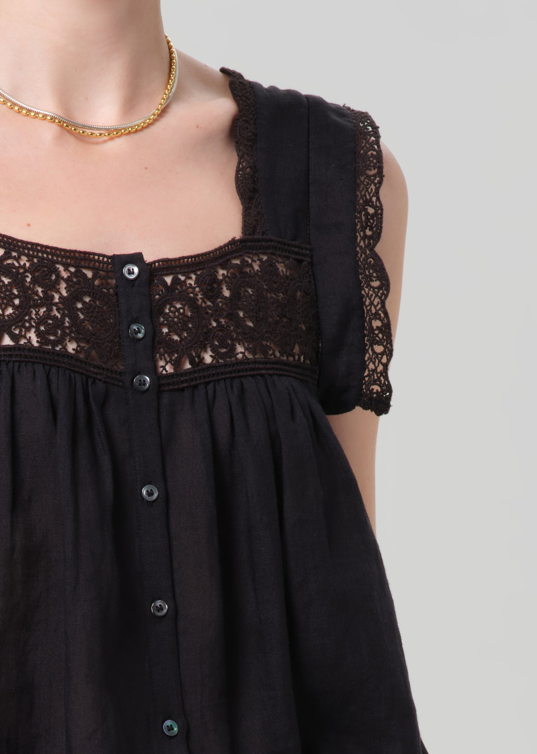 Black dress with lace details on a grey background