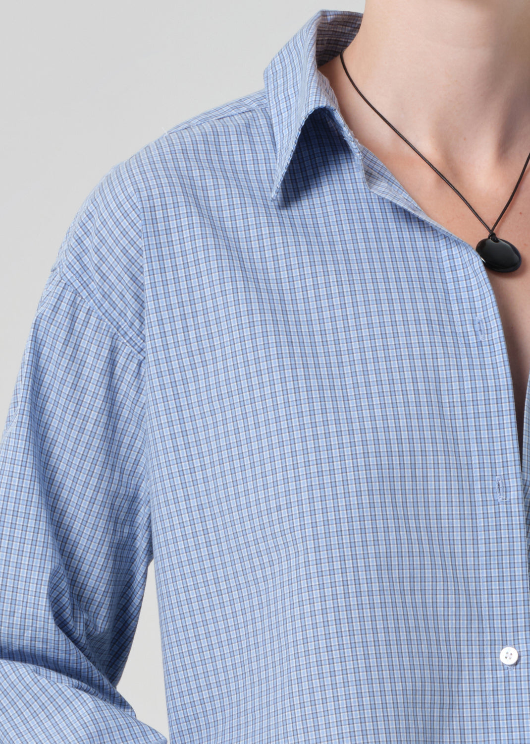 Close-up of a blue plaid shirt with a grey background