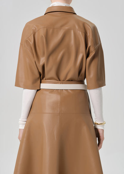 Brown leather outfit with a white shirt underneath on a plain background