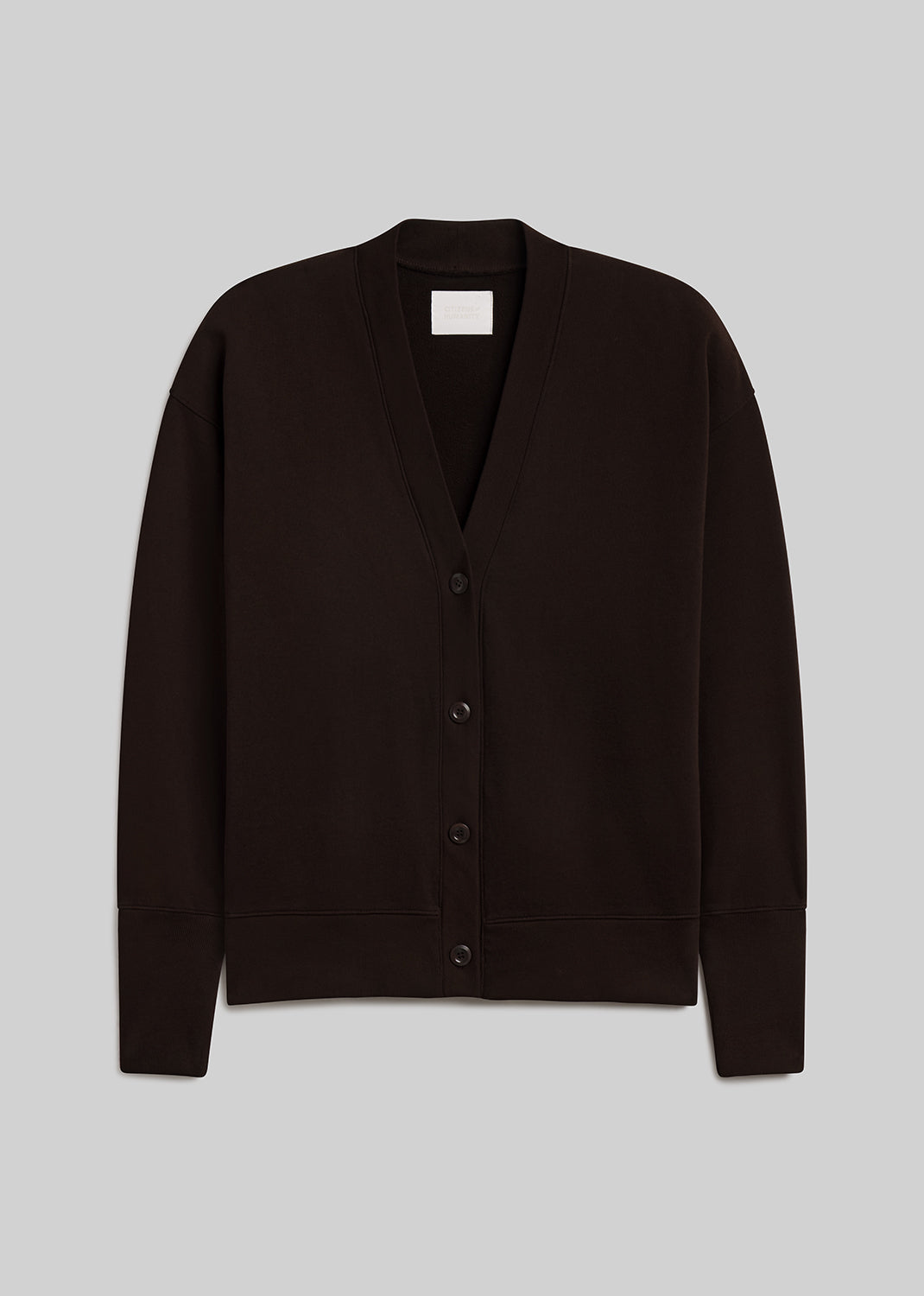 Dark chocolate brown fleece cardigan featuring a relaxed silhouette, deep V-neckline, four-button front closure, dropped shoulders, long sleeves, and ribbed cuffs and hem, front view on a grey background.