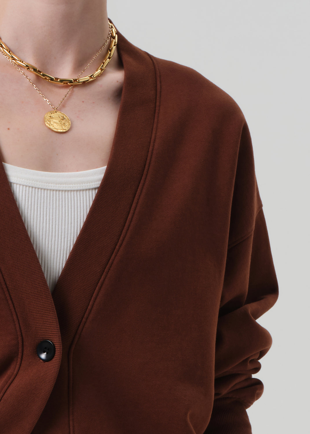 Brown cardigan worn by a person on a plain background