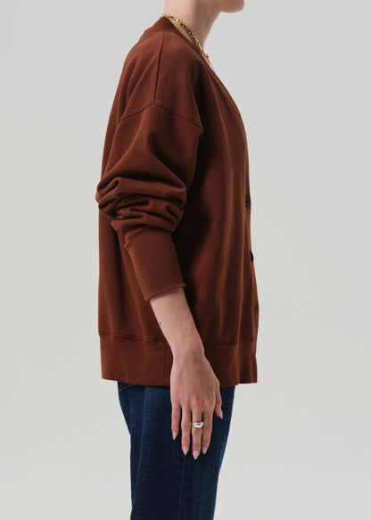 Brown cardigan worn by a person on a plain background