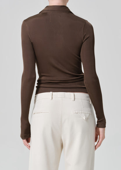 Brown long-sleeve top worn by a person on a plain background