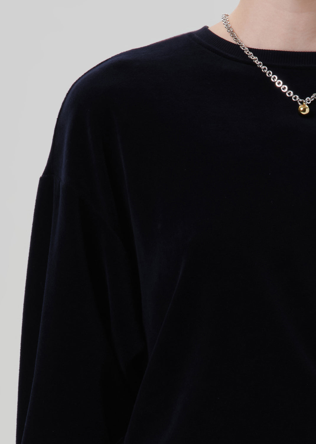 Black sweater on a grey background.