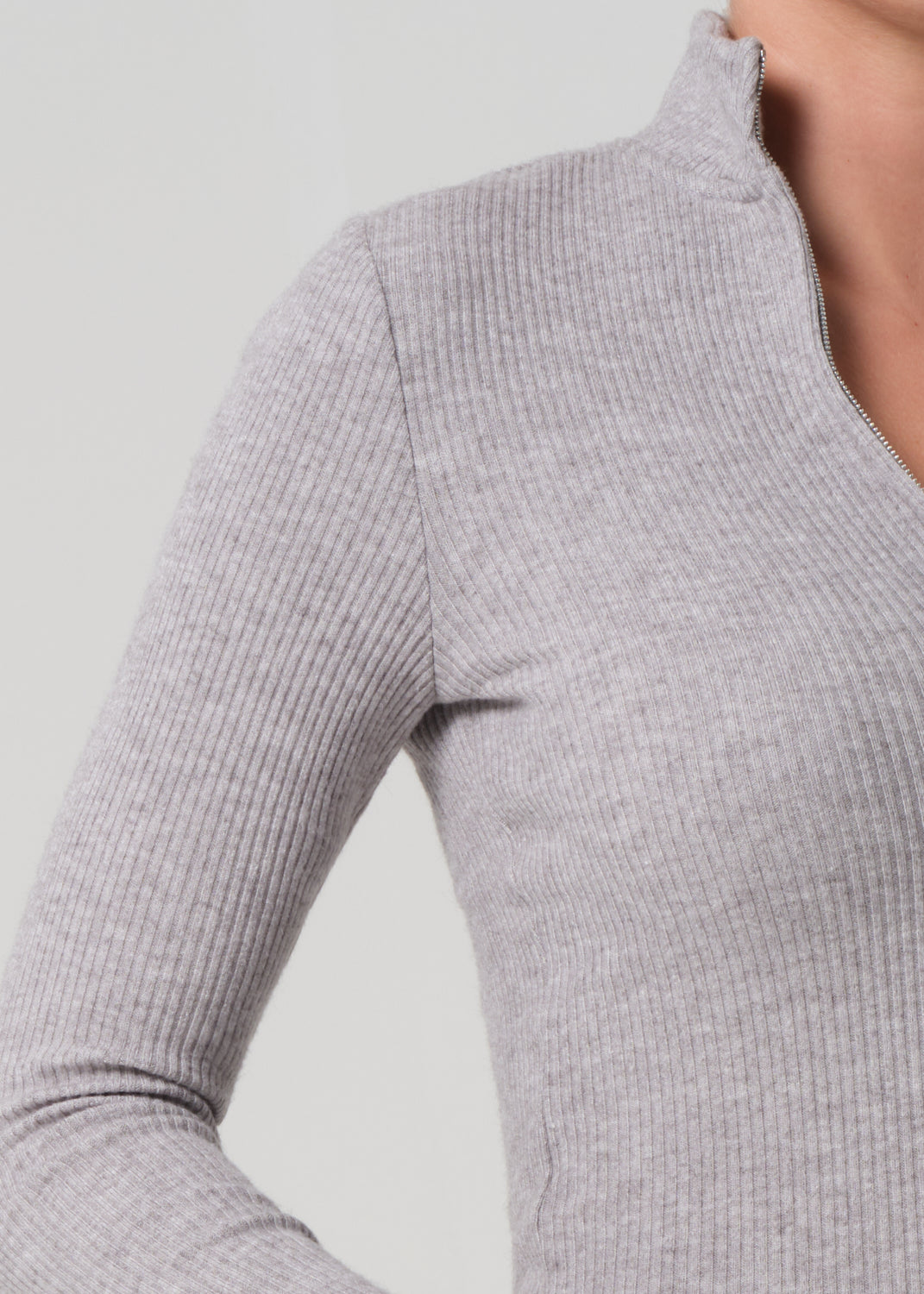Close-up of a gray ribbed long-sleeve top on a plain background