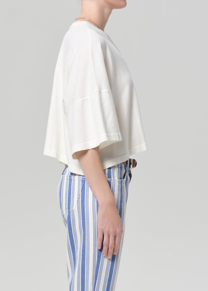 Person wearing a white top and blue striped pants on a gray background
