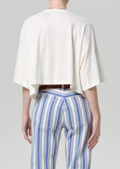 Person wearing a white top and blue striped pants on a gray background