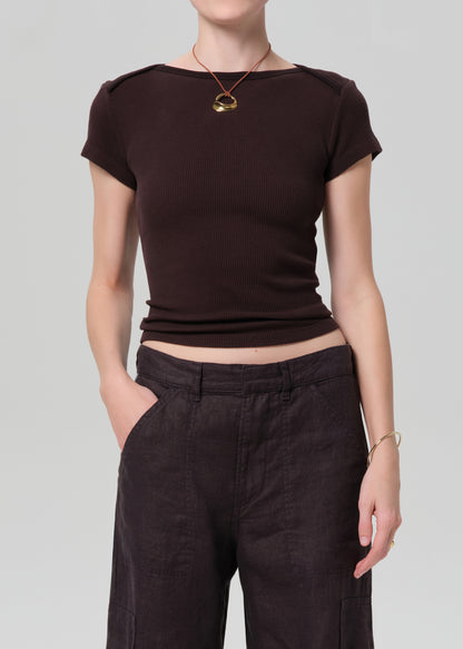 Person wearing a brown crop top and dark pants on a plain background