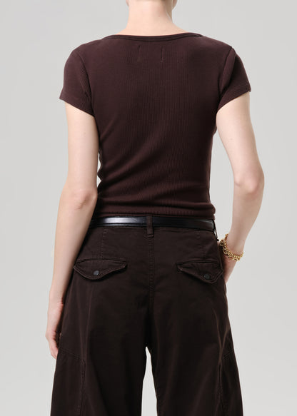 Rear view of a model wearing a dark brown short-sleeve ribbed knit top and dark brown pants with a black belt, against a grey background.