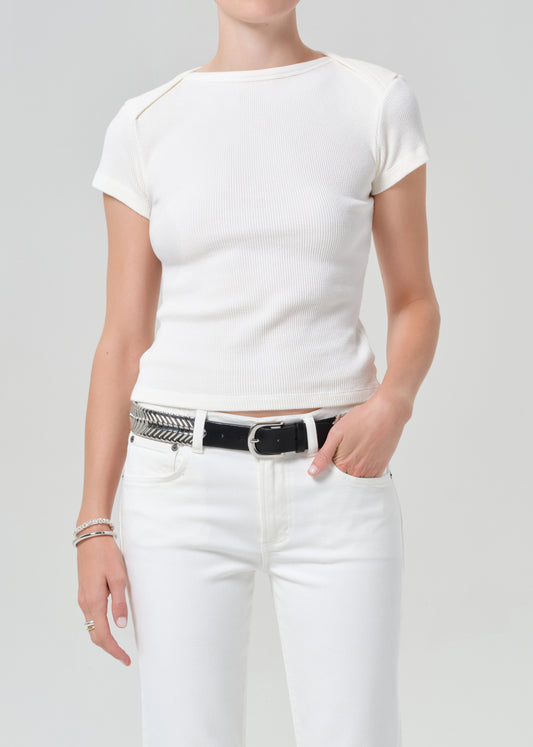 Person wearing a white t-shirt and white pants with a black belt on a plain background