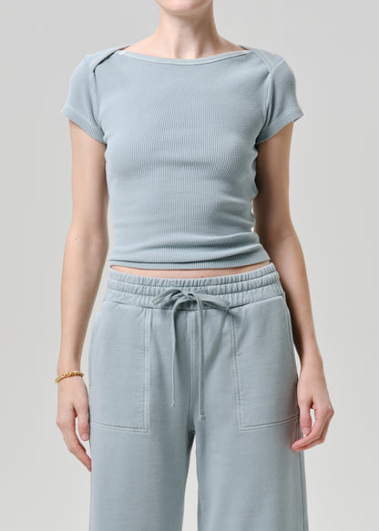 Person wearing a light blue ribbed top and matching pants on a grey background