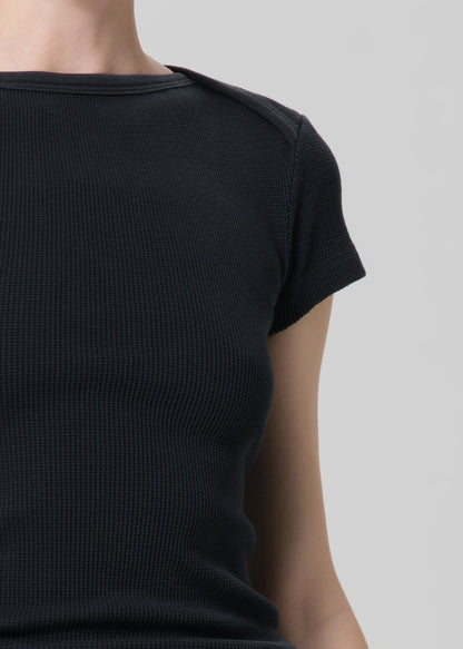 Black ribbed t-shirt worn by a person on a light gray background