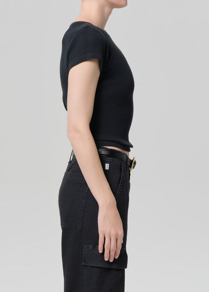 Person wearing a black t-shirt and black pants on a light gray background