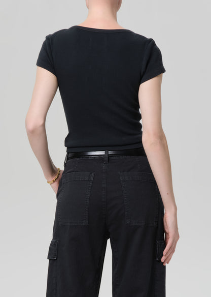 Person wearing a black t-shirt and black cargo pants on a light gray background