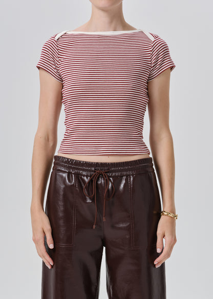 A model wearing a short-sleeve striped knit top with red and white horizontal stripes, paired with dark brown faux-leather pants, against a grey background.