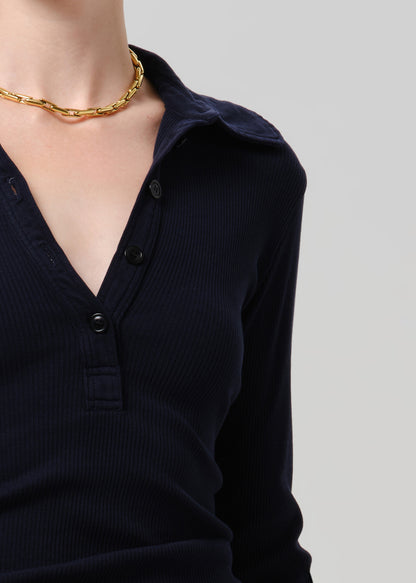 Close up of person wearing blue top on a grey background