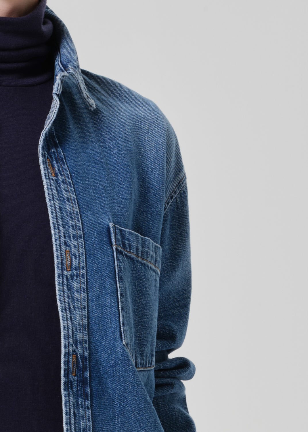Blue denim shirt with a plain background
