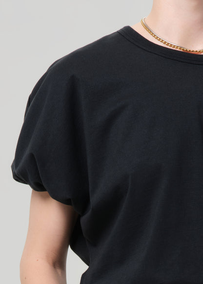 Black t-shirt worn by a person on a gray background