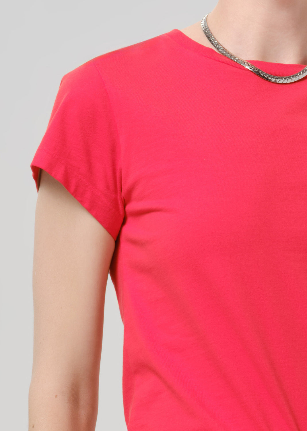 Close up of bright red t-shirt on a grey background