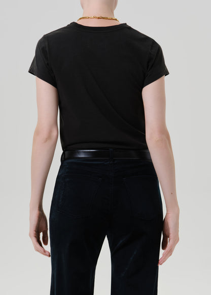 Person wearing a black short sleeve crewneck tee with black wide leg jeans viewed from the back on a grey background