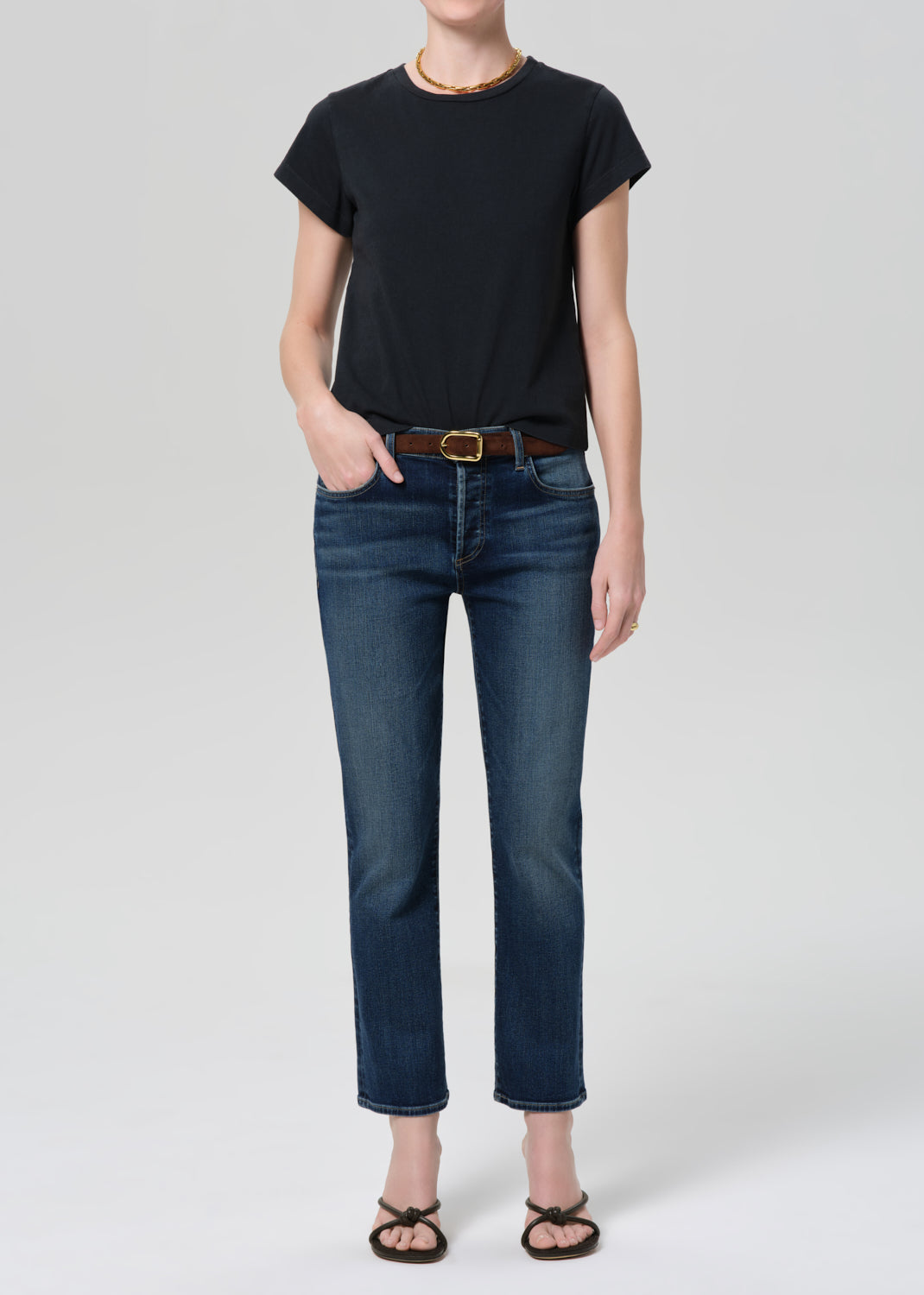 Person wearing washed black tee with blue jeans