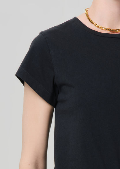 Person wearing washed black tee with blue jeans