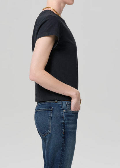 Person wearing washed black tee with blue jeans