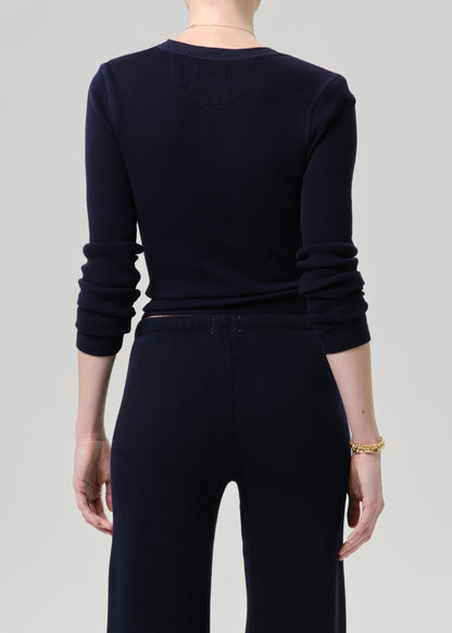 A model shown from the back wearing a dark navy long-sleeve knit top and matching dark navy wide-leg pants against a grey background.