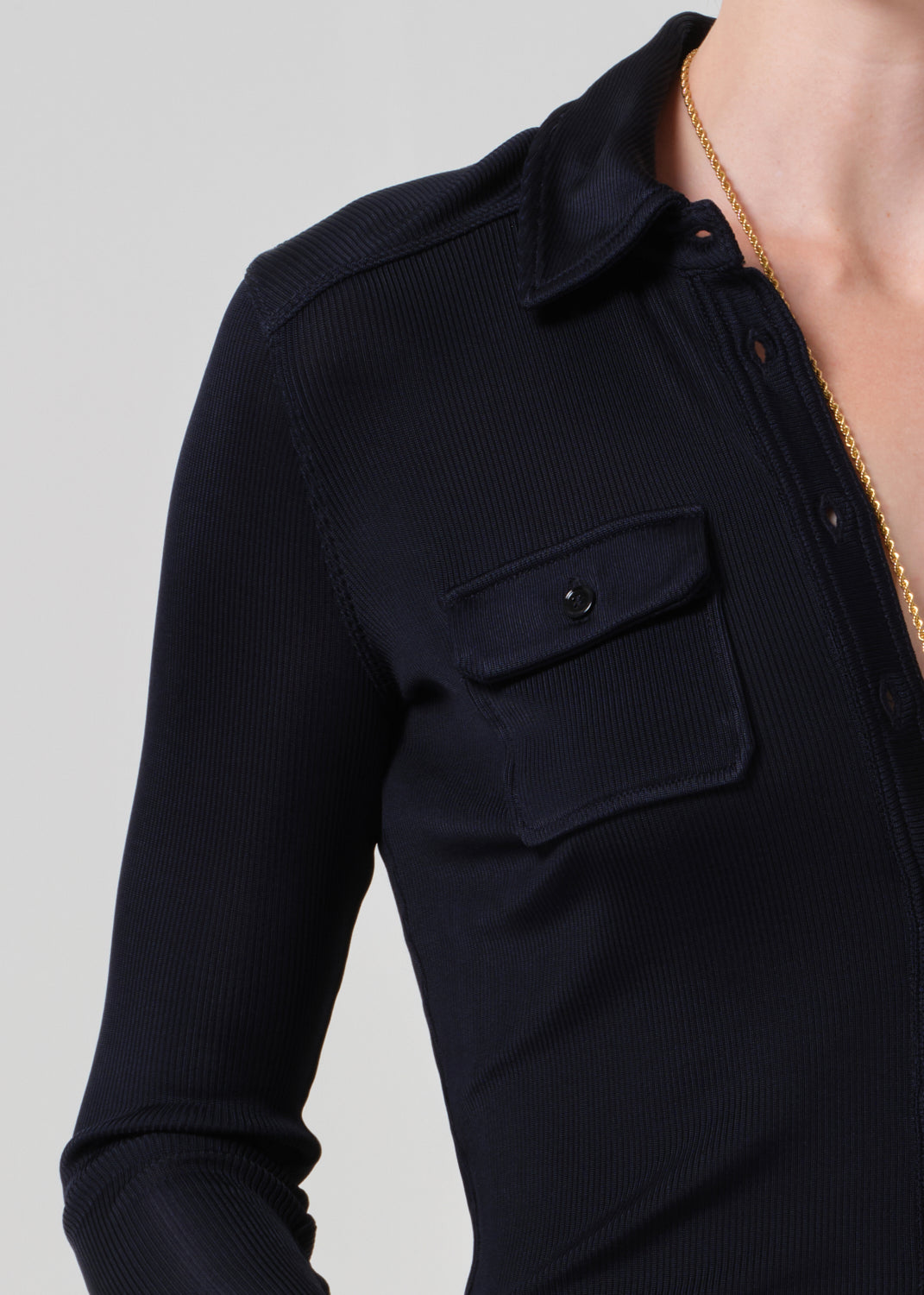 Person wearing a navy shirt on a plain background