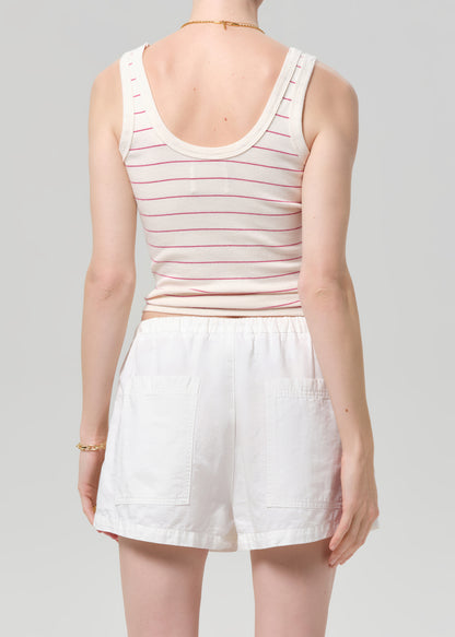 Person wearing a striped tank top and white shorts on a gray background