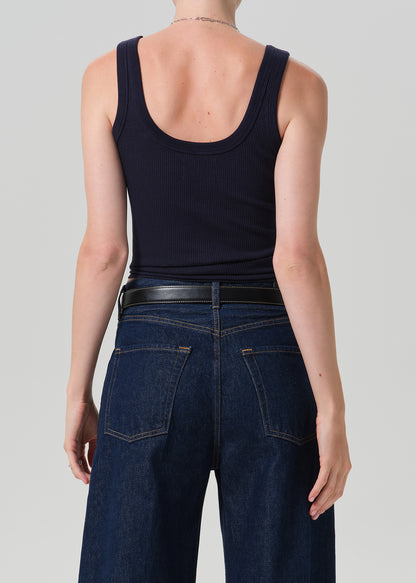Rear view of a model wearing a dark navy ribbed tank top and dark blue wide-leg jeans with a black belt, against a grey background.