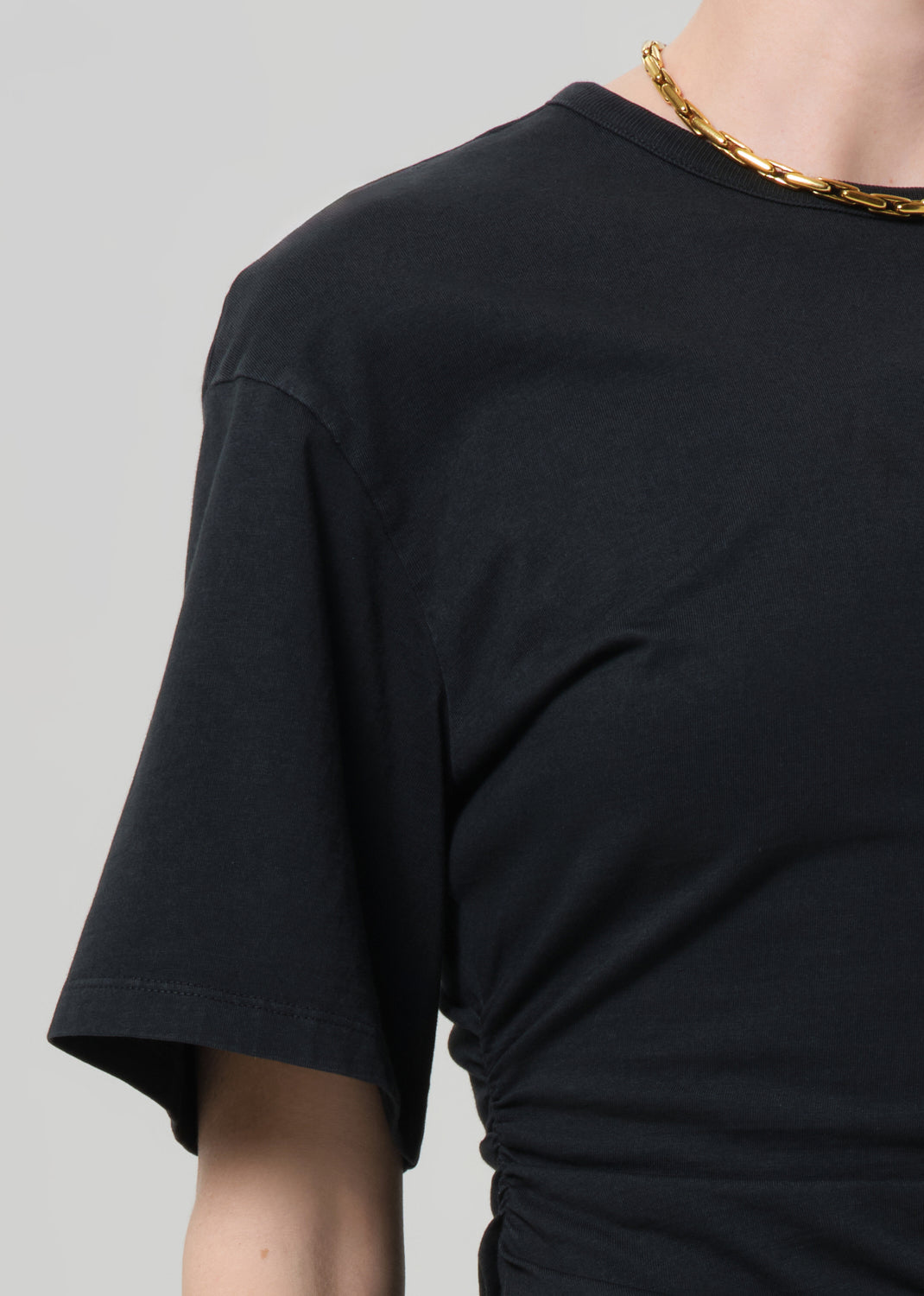 Black t-shirt worn by a person on a gray background