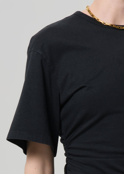 Black t-shirt worn by a person on a gray background