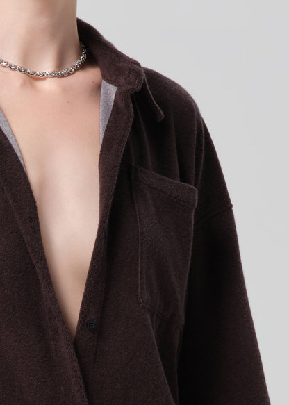 Person wearing a brown terry outfit with a deep neckline on a plain background
