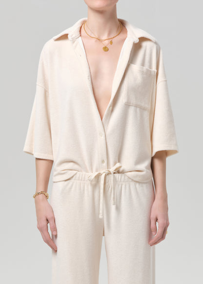 Person wearing a cream-colored terry set with a plain background