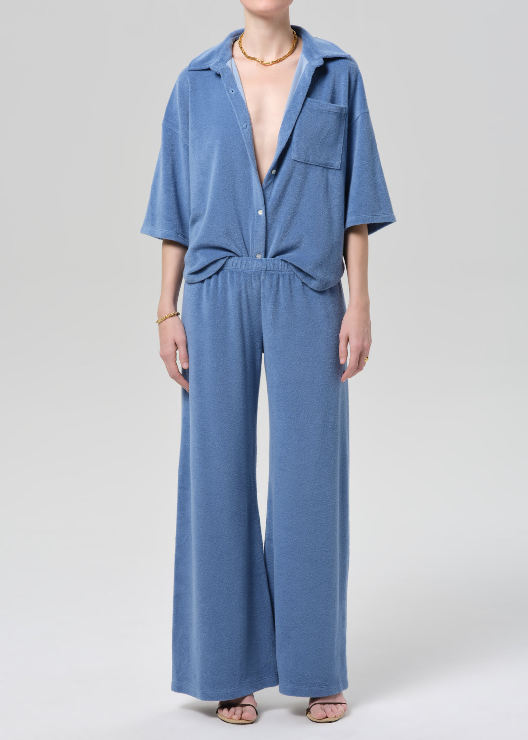 Blue terry set worn by a person on a plain background