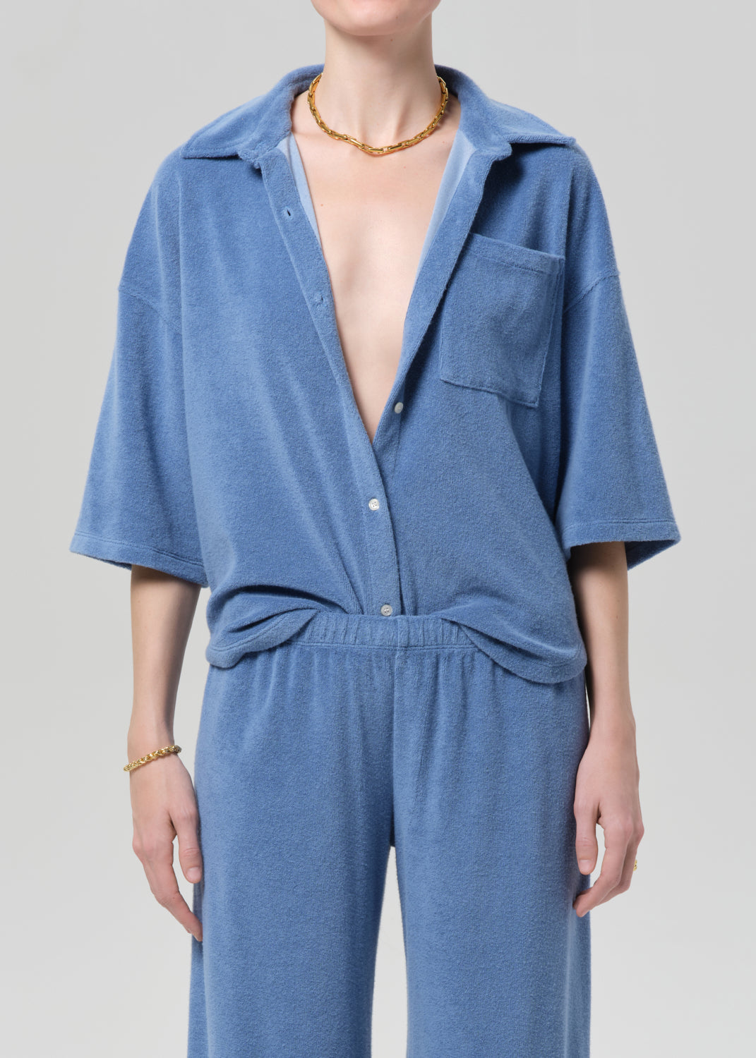 Blue terry set worn by a person on a plain background