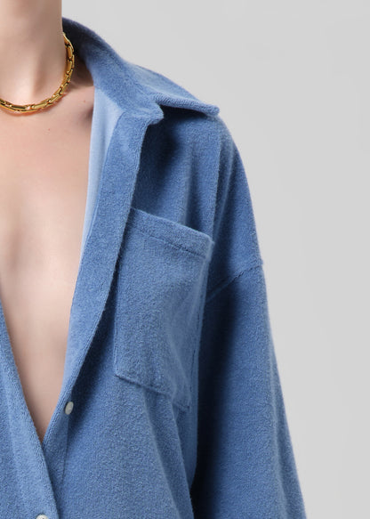 Blue shirt with a plunging neckline on a plain background