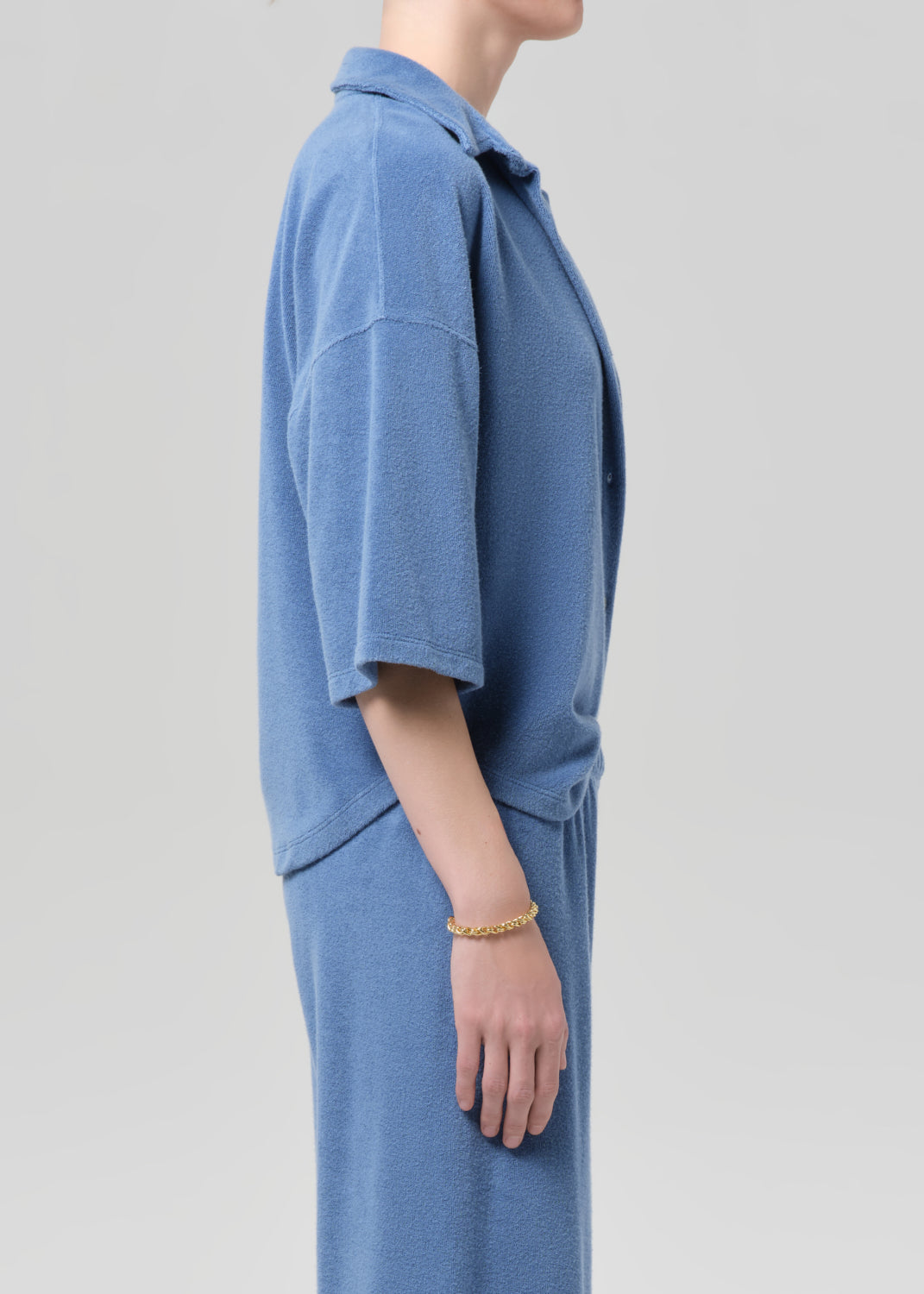 Blue terry set worn by a person on a plain background