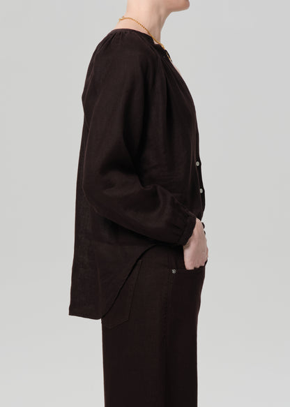 Person wearing a dark brown outfit on a light gray background