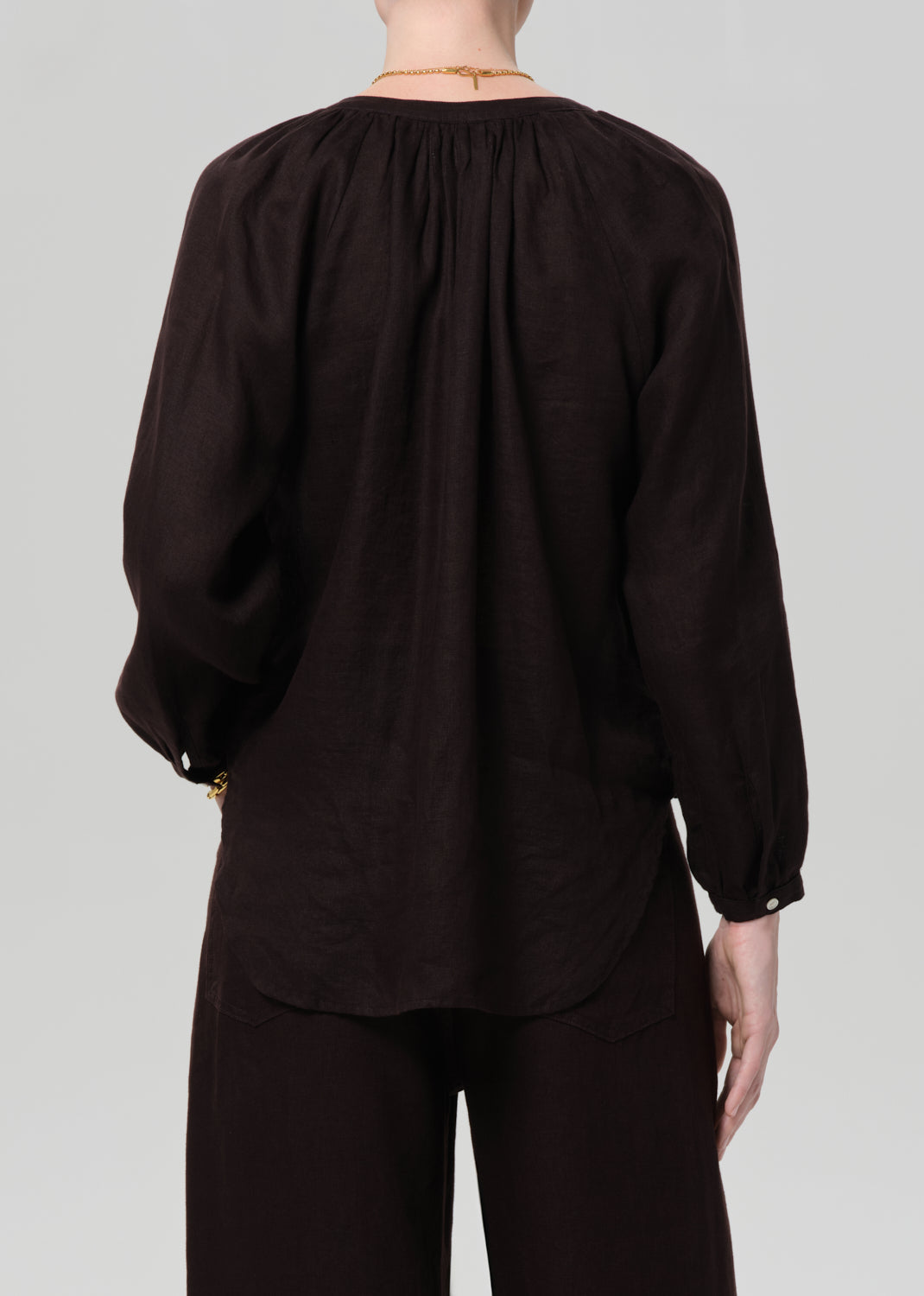 Brown blouse with long sleeves on a plain background