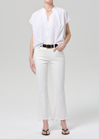 Person wearing a white blouse and pants on a plain background